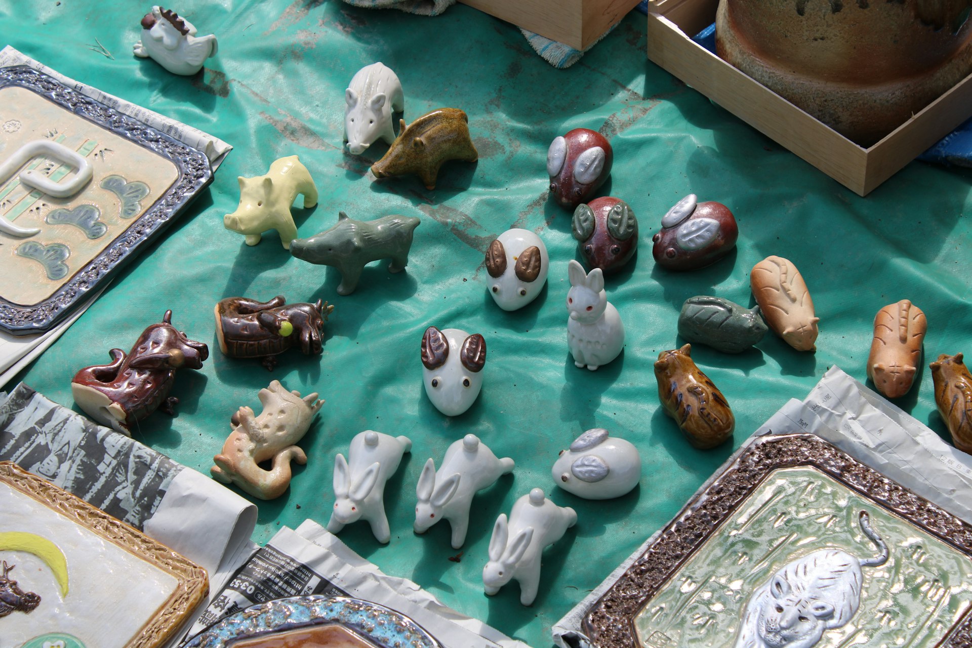 Collection of small ceramic animal figurines arranged on a cloth