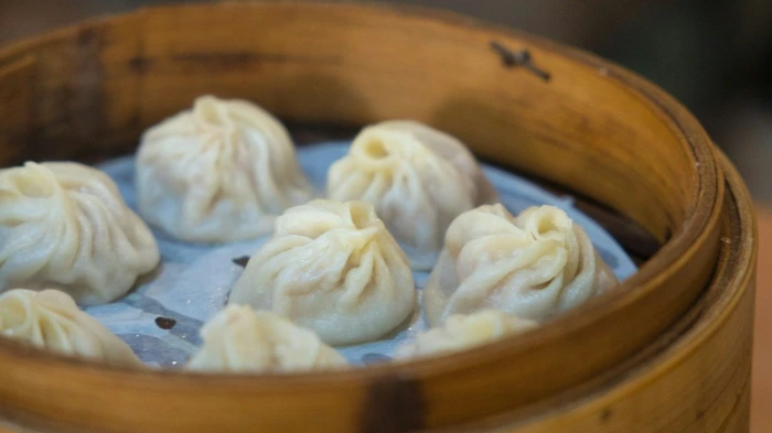 a wooden container filled with dumplings on top of a table